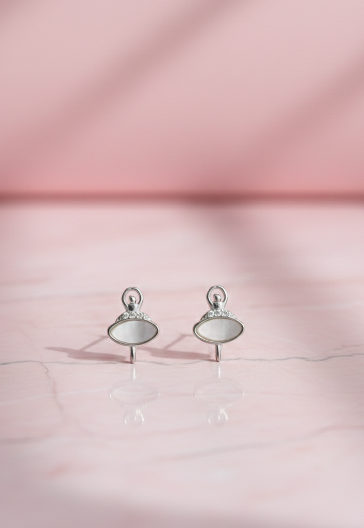 Pair of silver earrings with round stones on a pink fabric background