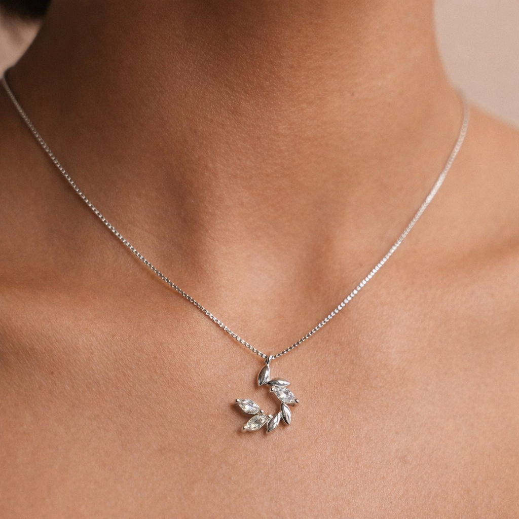 Rose gold necklace and earrings with diamond-like stones on a soft pink background